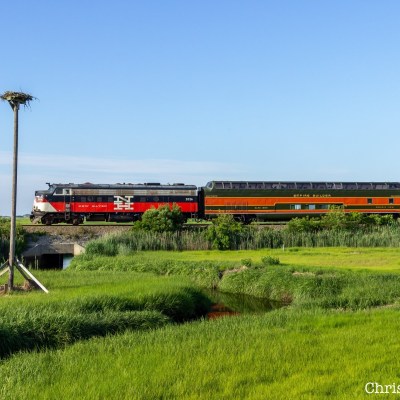 a train traveling down train tracks near a field