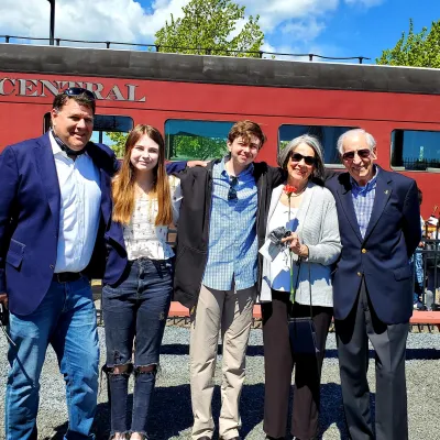 a man standing in front of a group of people posing for the camera
