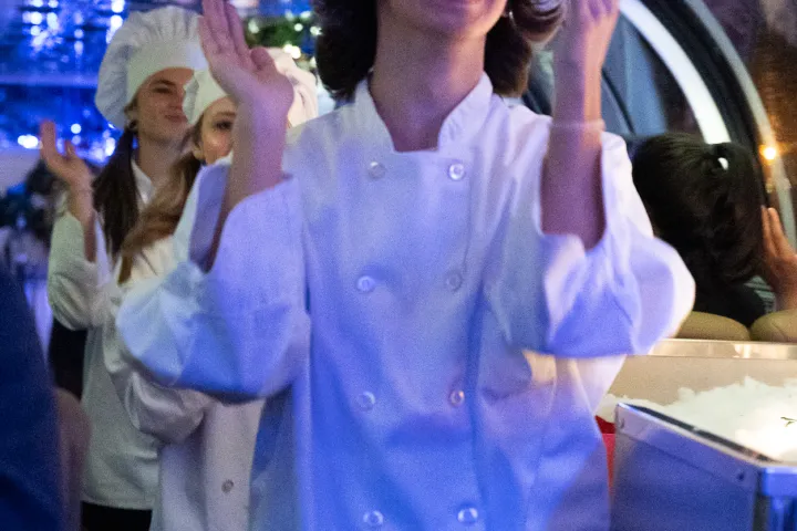 a group of people standing in front of a large blue hat