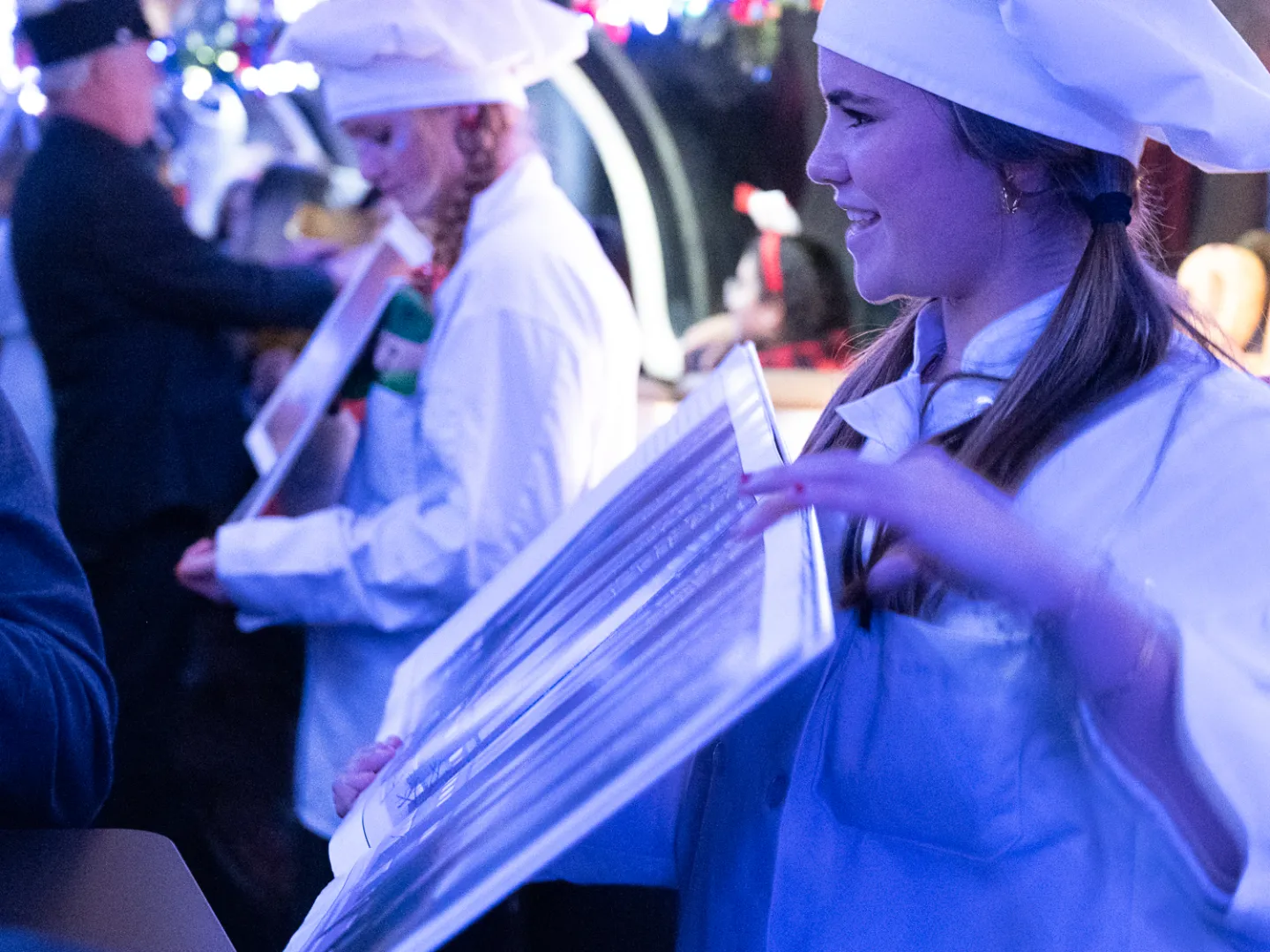 a man wearing a hat standing in front of a crowd
