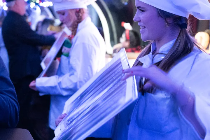 a man wearing a hat standing in front of a crowd