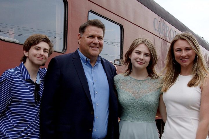 father and children in front of train