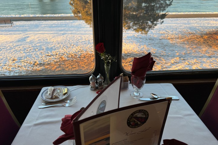 Table set for two by a window overlooking a snowy riverbank.